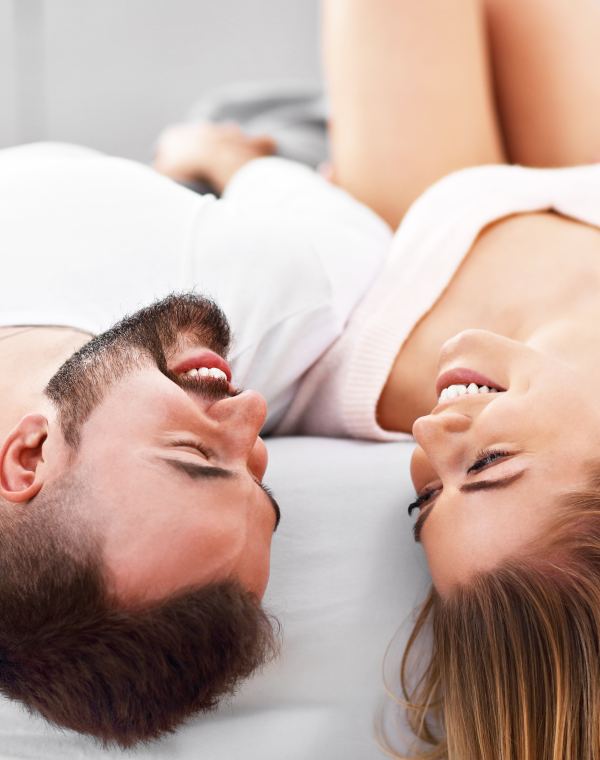 Homme et femme complices allongés sur un lit